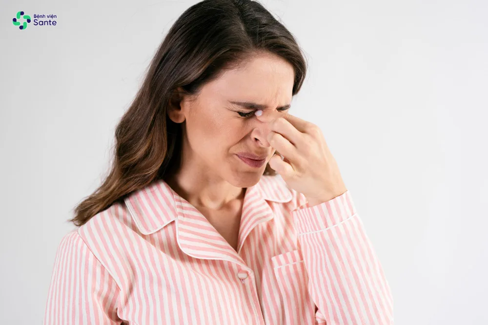 Bệnh viện Sante - Nghẹt Mũi Một Bên Khi Nằm Ngủ: Vì Sao Càng Xịt Thuốc Càng Tắc? Người phụ nữ khó chịu vì bị nghẹt cứng một bên mũi khi nằm ngủ